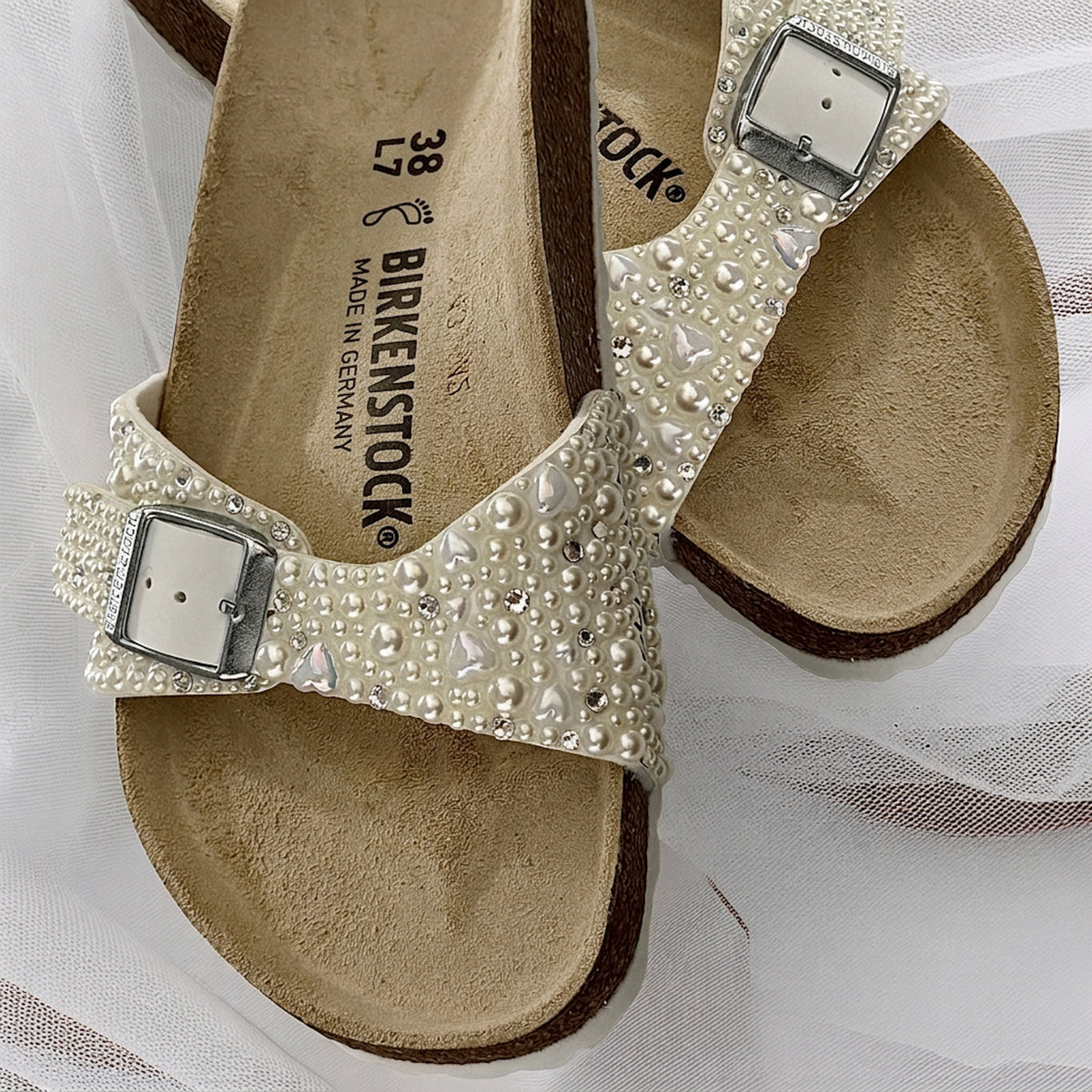 Custom Birkenstock Madrid bridal sandals embellished with ivory pearls with delicate heart and crystal accents on soft bridal tulle.