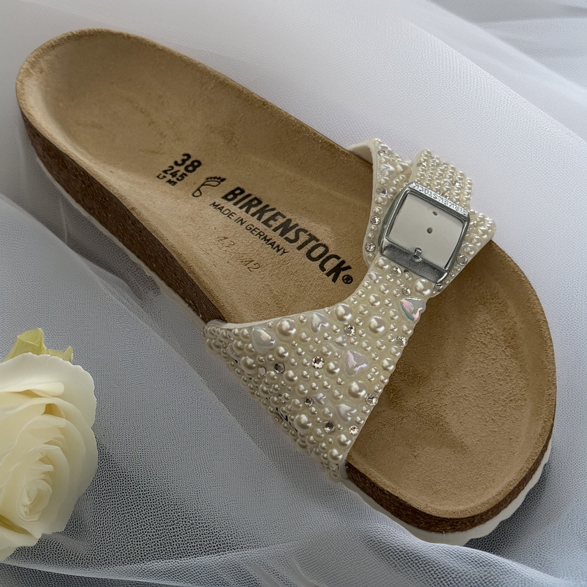 Single Birkenstock Madrid bridal sandal decorated with ivory pearls with delicate heart and crystal accents, styled with soft tulle and an ivory rose.